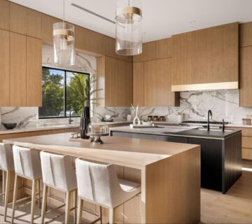 Modern kitchen featuring wooden cabinets and white marble countertops for a clean, natural look.