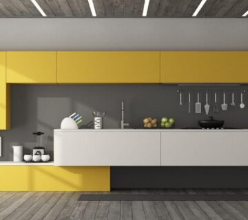 Modern kitchen with gray walls and two-tone yellow and white cabinet design.