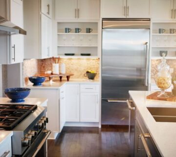 A side view of a modern kitchen that has white countertops and cabinets.
