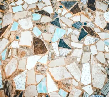 A close up of a mosaic tile floor with white and blue tiles 