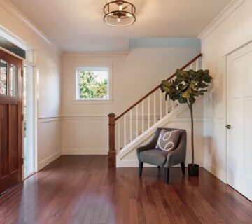 A side view of an entrance of a home with hardwood floors and white interior 