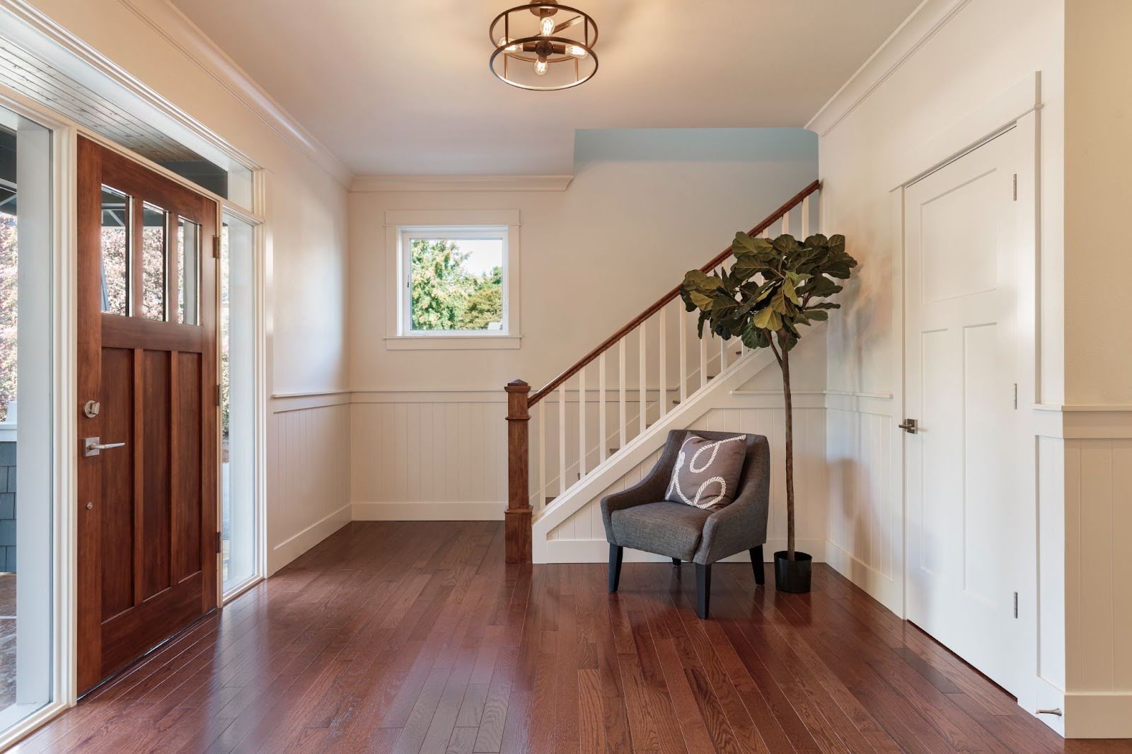 A side view of an entrance of a home with hardwood floors and white interior.