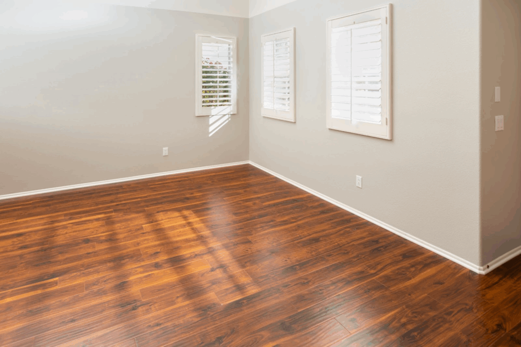 An empty room with natural lighting and hardwood floors.